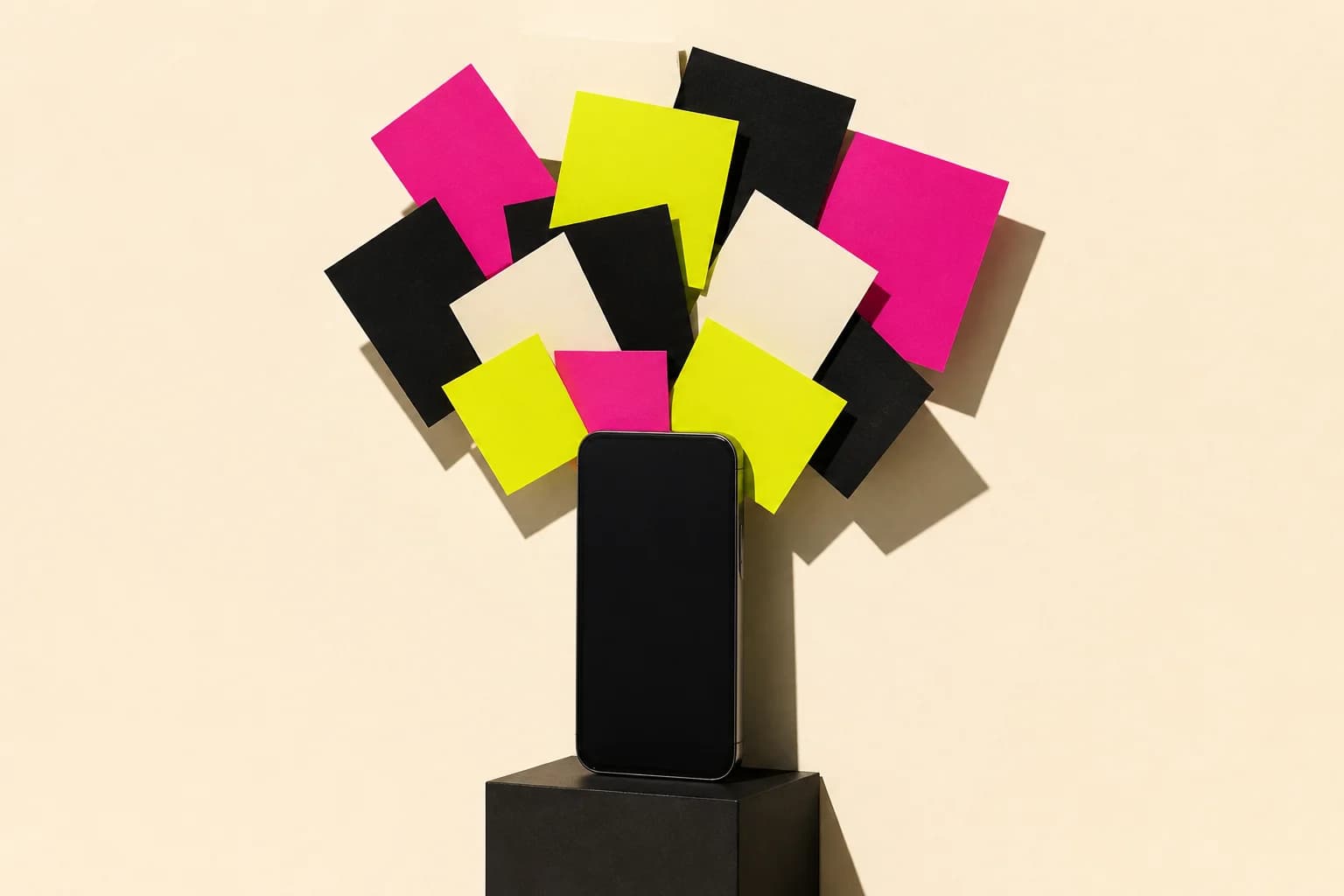 A smartphone on a black plinth with blank cards in magenta, yellow, black and cream fanning out above it like a social feed.